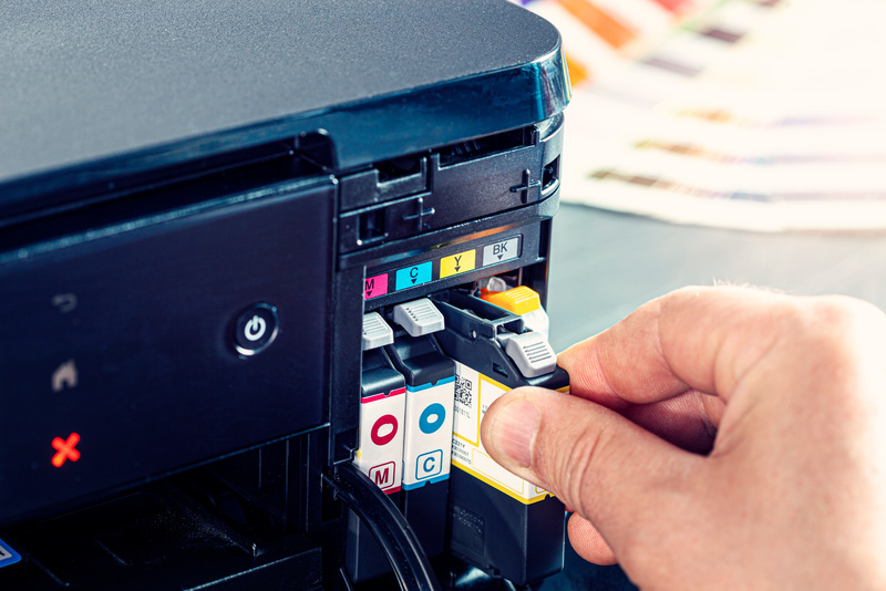 Technician changing Cartridge Inks in a Computer Printer